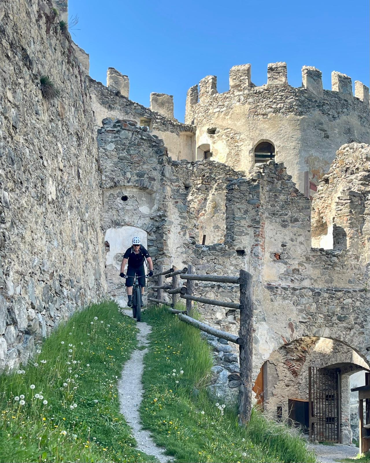 MTB-Fahrer auf Flow-Trail durch historische Burgruine im Vinschgau