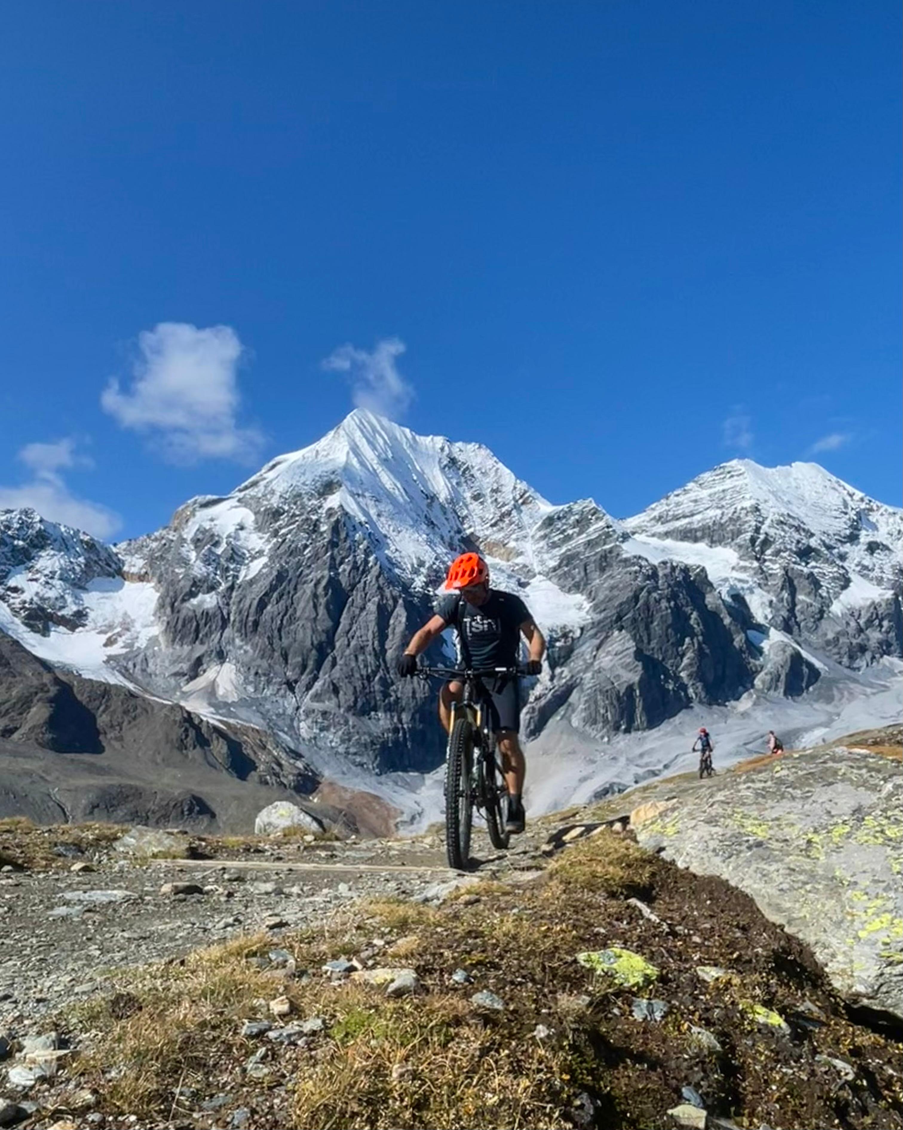 Biker auf hochalpinem Trail vor vergletscherten Gipfeln, Nationalpark Stilfserjoch